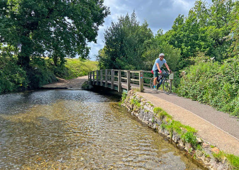 Cycling over a small bridge next to a ford