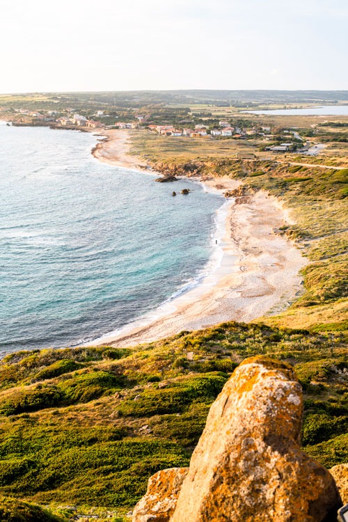 A view out across a dramatic coastal peninsula with a sandy beach