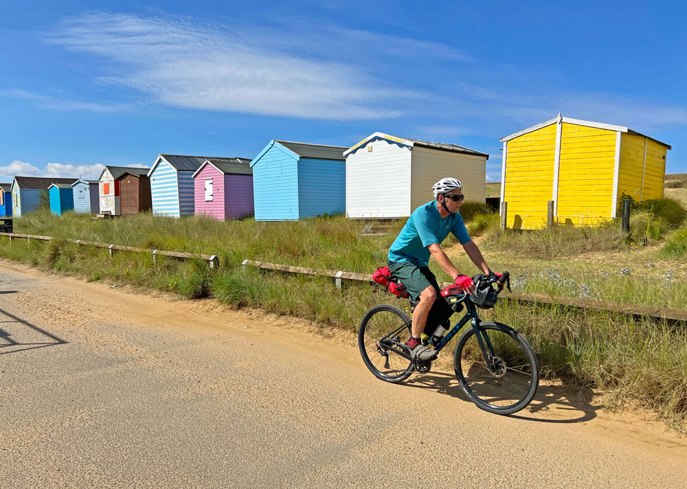 Cycling past colourful beach huts in Norfolk
