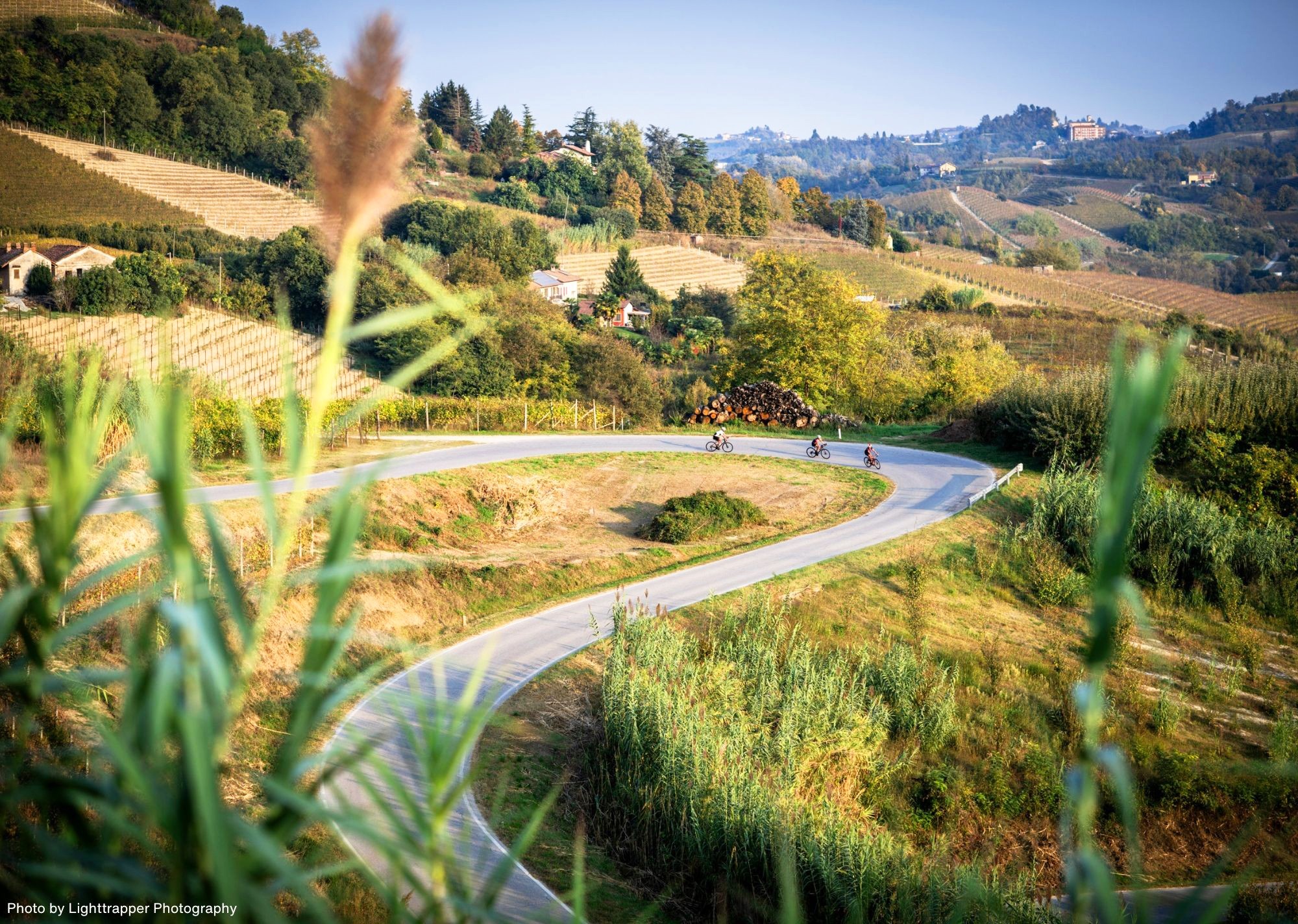 Cyclists on a twisting road through hills