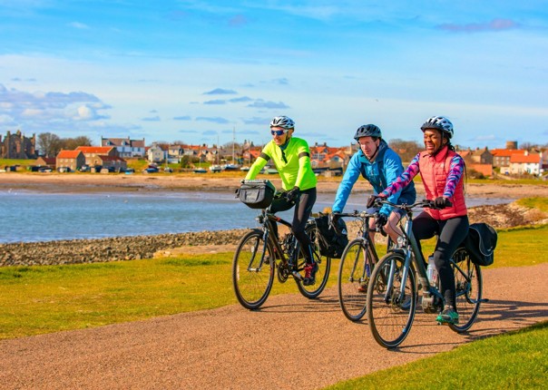 Three cyclists riding in Northumberland on a cycling tour