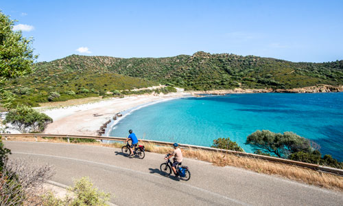 Cycling past a white beach in Sardinia